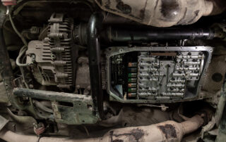 Close-up of a vehicle's transmission system with the cover removed, revealing internal components and gears, highlighting the importance of a routine fluid flush for optimal performance.