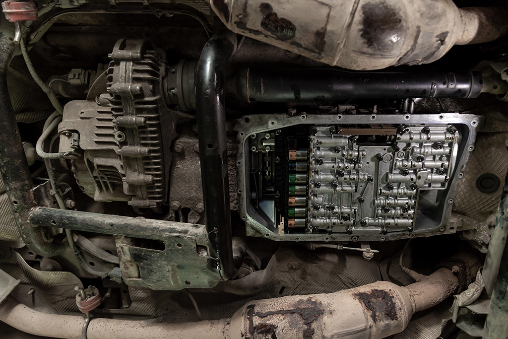 Close-up of a vehicle's transmission system with the cover removed, revealing internal components and gears, highlighting the importance of a routine fluid flush for optimal performance.