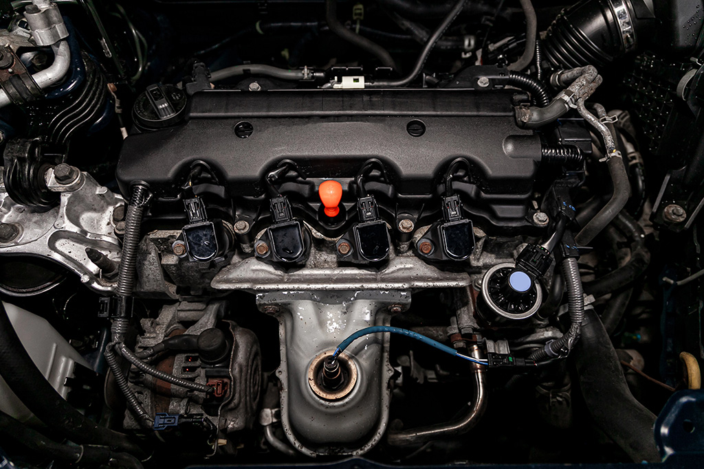 Close-up of a car engine showcasing ignition coils, spark plugs, and various components. With visible wiring and gleaming metal parts, the engine is clean—ideal for those considering engine swaps to boost performance or customize their ride.